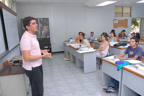 La imagen muestra un docente dando clases.