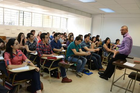 Profesor dando clases a un grupo de estudiantes universitarios.