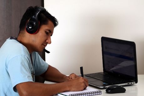 Muchacho estudiando con una computadora.
