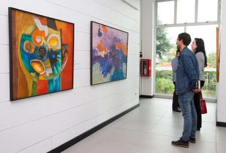 Dos personas viendo una obra de arte en la Galería CU.