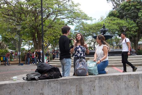 Estudiantes conversando en el pretil.
