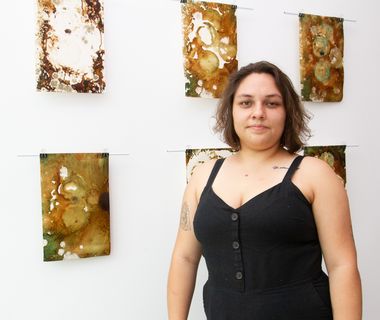 La artista Sofía Ureña junto a algunas de sus oras denominadas Monotipia de esporas, las cuales forman parte de la exposición que está actualmente en la Galería del Consejo Universitario. (Foto: Andrea Jiménez, CU)